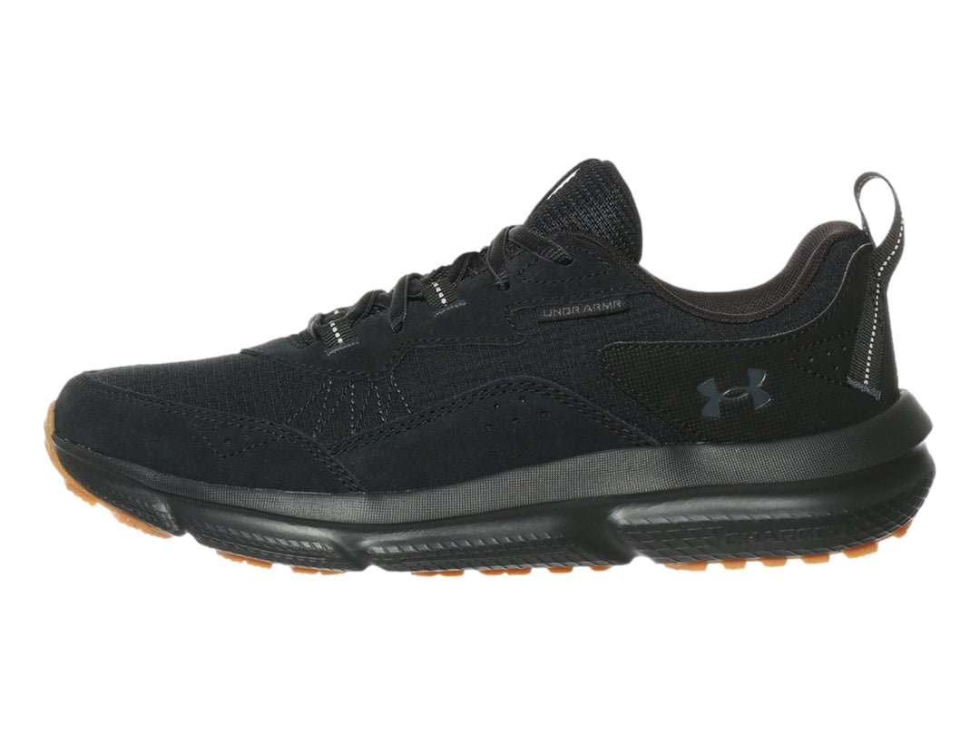 Tenis deportivo Under Armour de color negro con suela marrón, vista lateral.