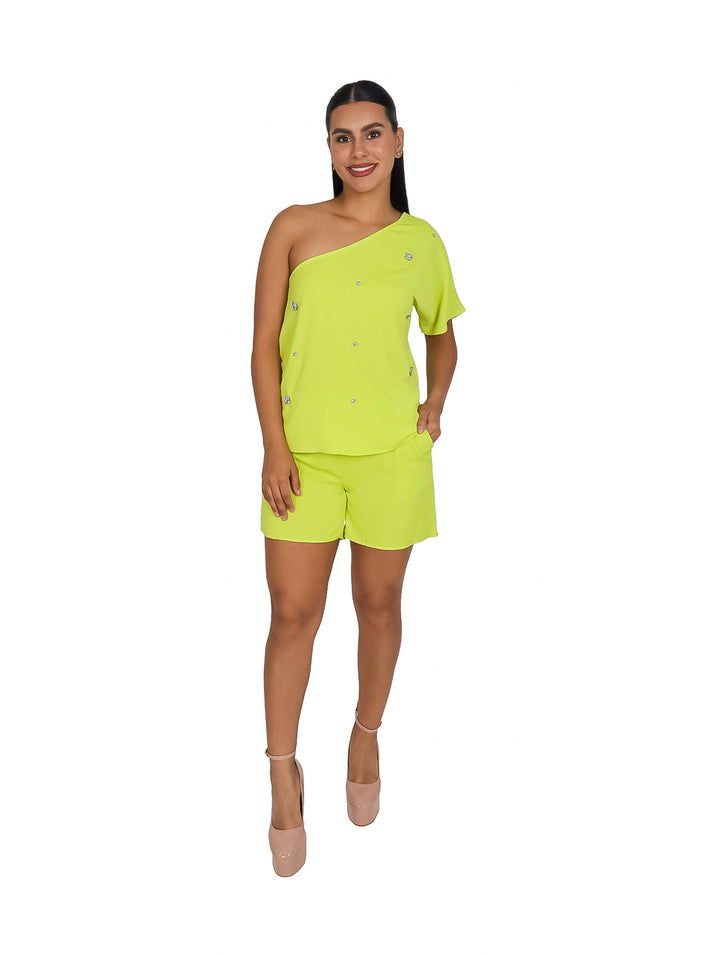 Mujer vistiendo un conjunto de dos piezas color lima con blusa de un solo hombro y shorts cortos.