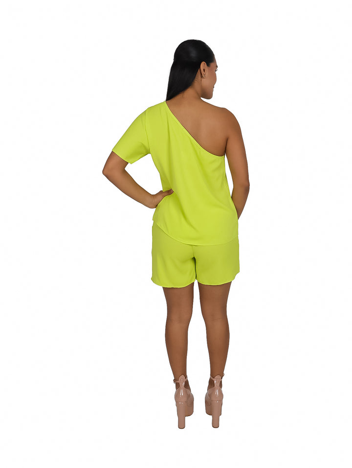 Mujer vistiendo un conjunto de dos piezas color lima con blusa de un solo hombro y shorts cortos.