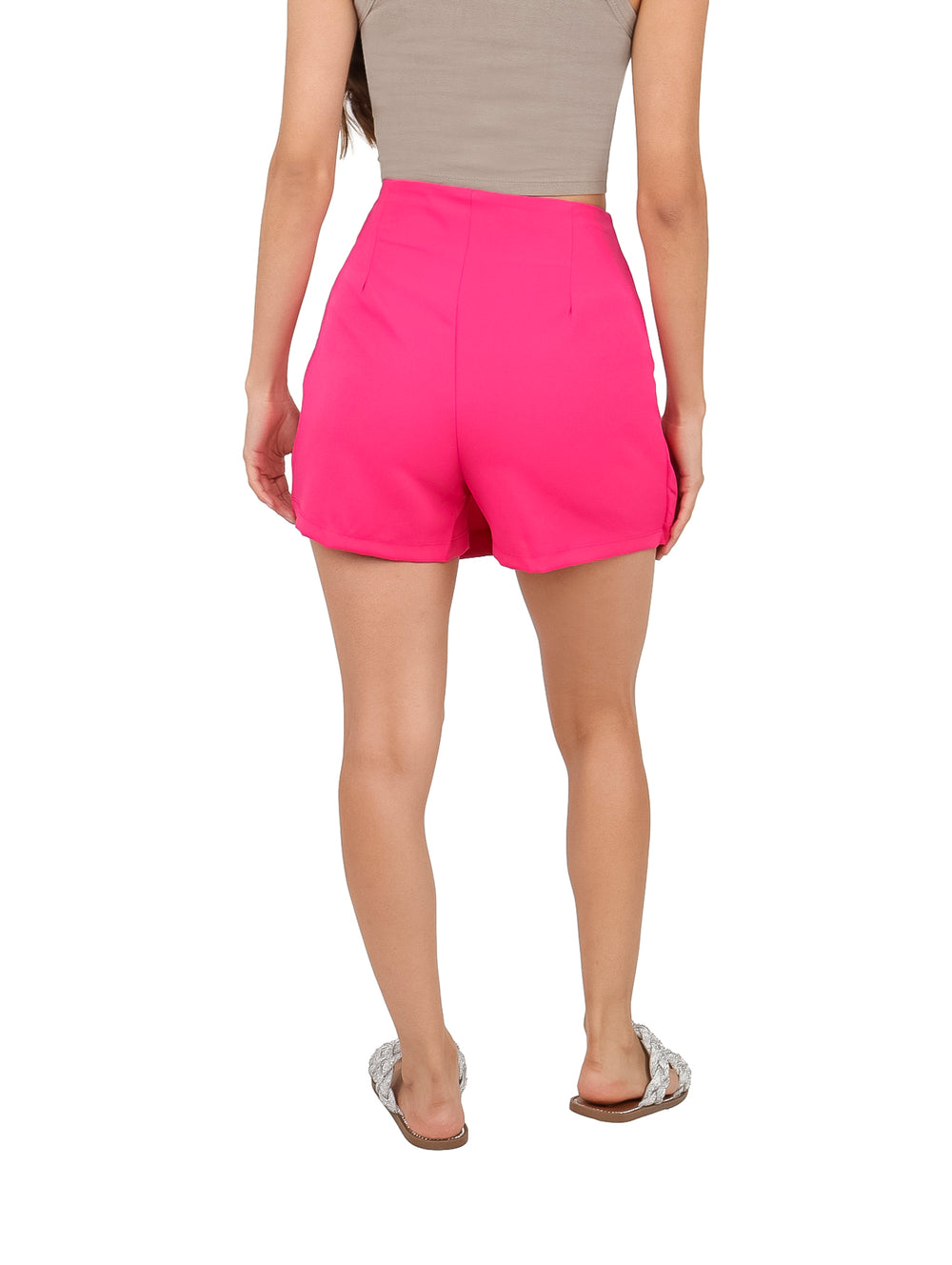 Mujer vistiendo un short falda color fiusha con detalles de piedras grandes decorativas en el frente.