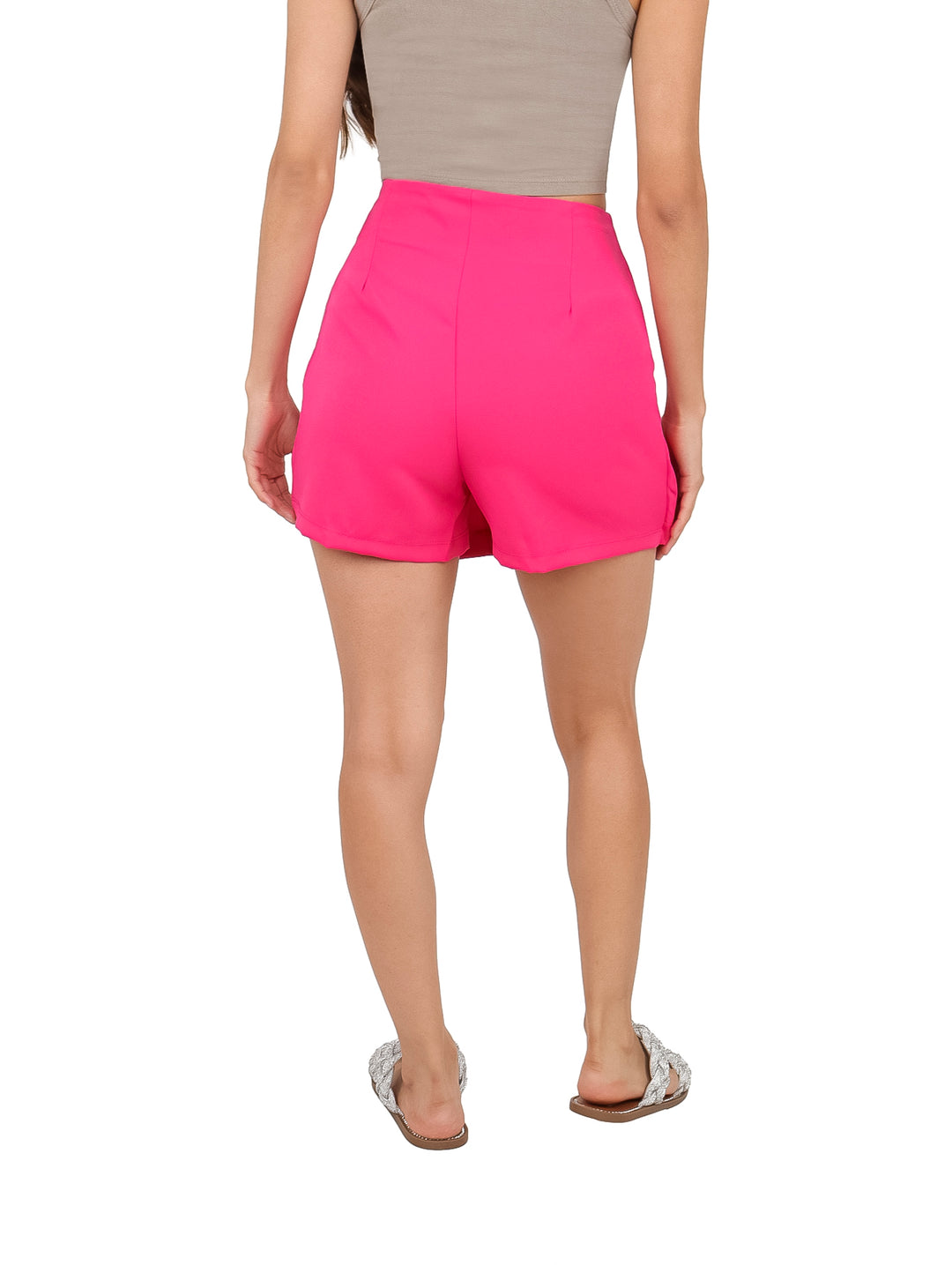 Mujer vistiendo un short falda color fiusha con detalles de piedras grandes decorativas en el frente.