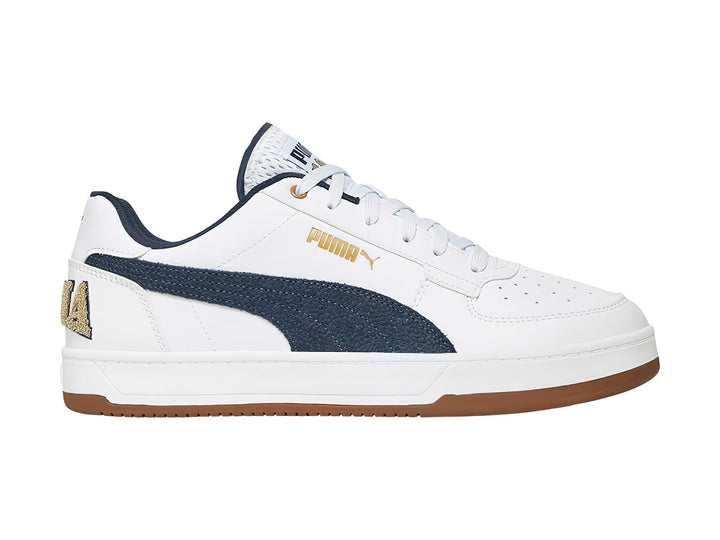 Tenis PUMA blancos con franja azul marino y suela color café.