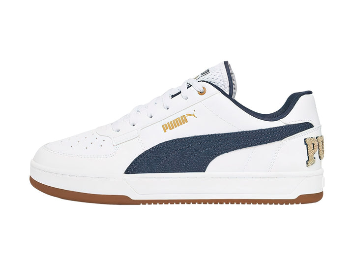 Tenis PUMA blancos con franja azul marino y suela color café.