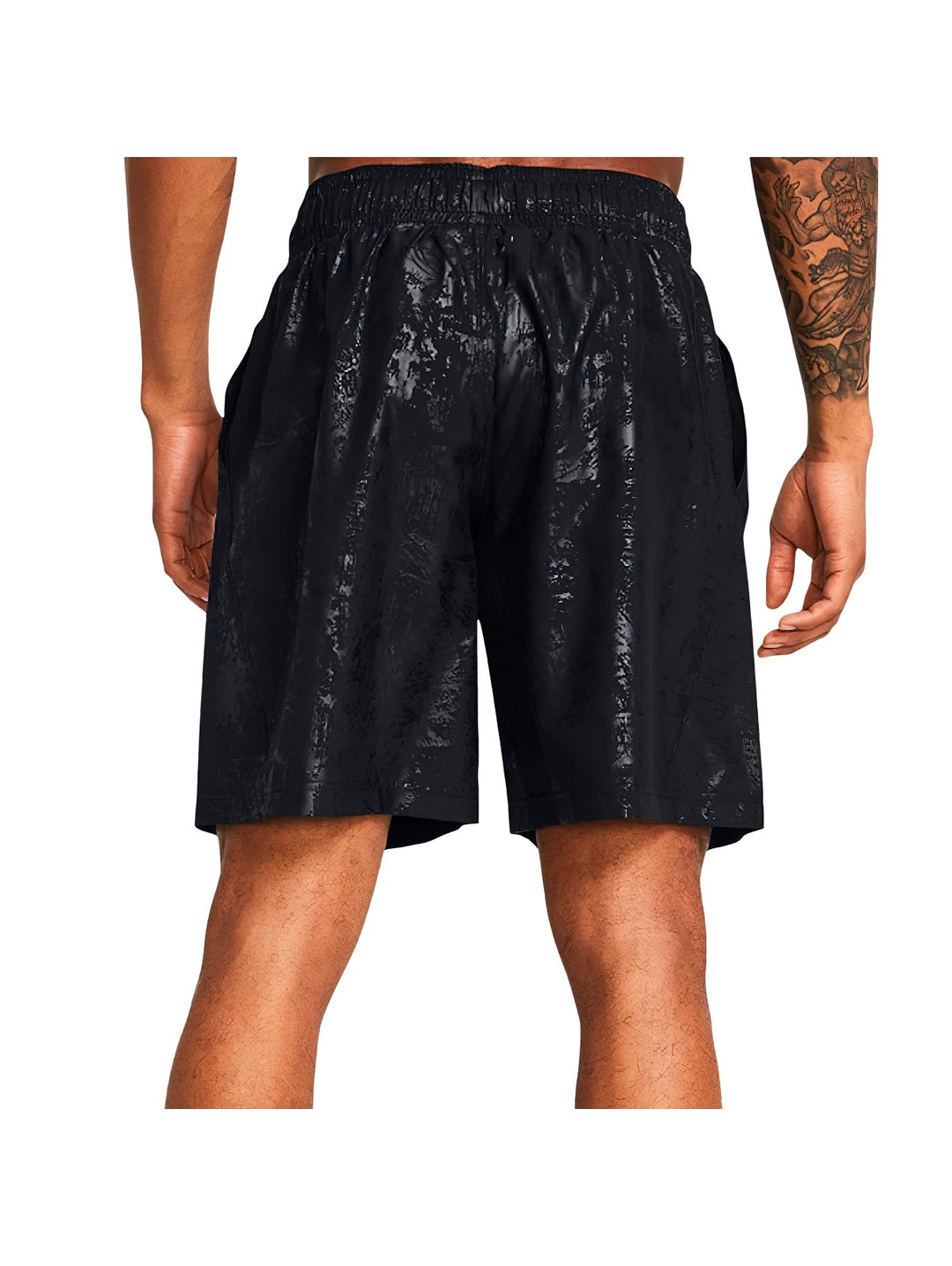 Pantalones cortos deportivos Under Armour color negro con textura grabada y logo amarillo en la pierna.