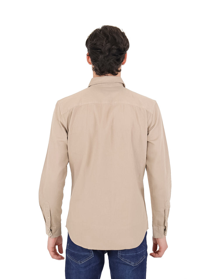Hombre vistiendo una camisa casual de manga larga en color beige con dos bolsillos frontales.