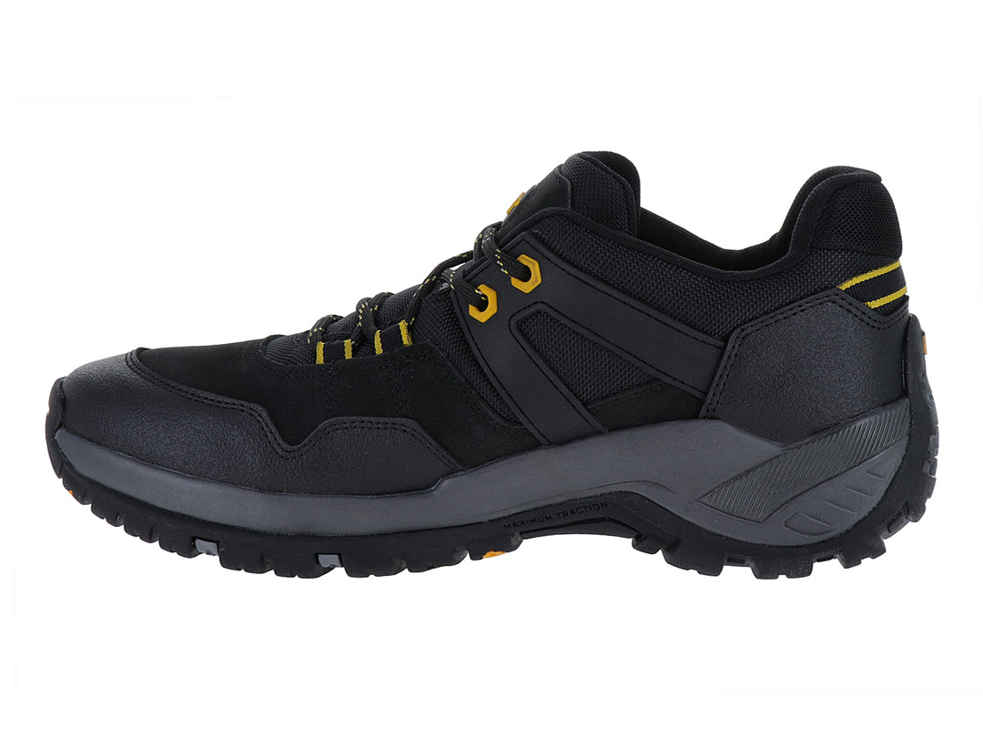 Zapato deportivo Caterpillar en color negro y gris oscuro con detalles amarillos y suela robusta.
