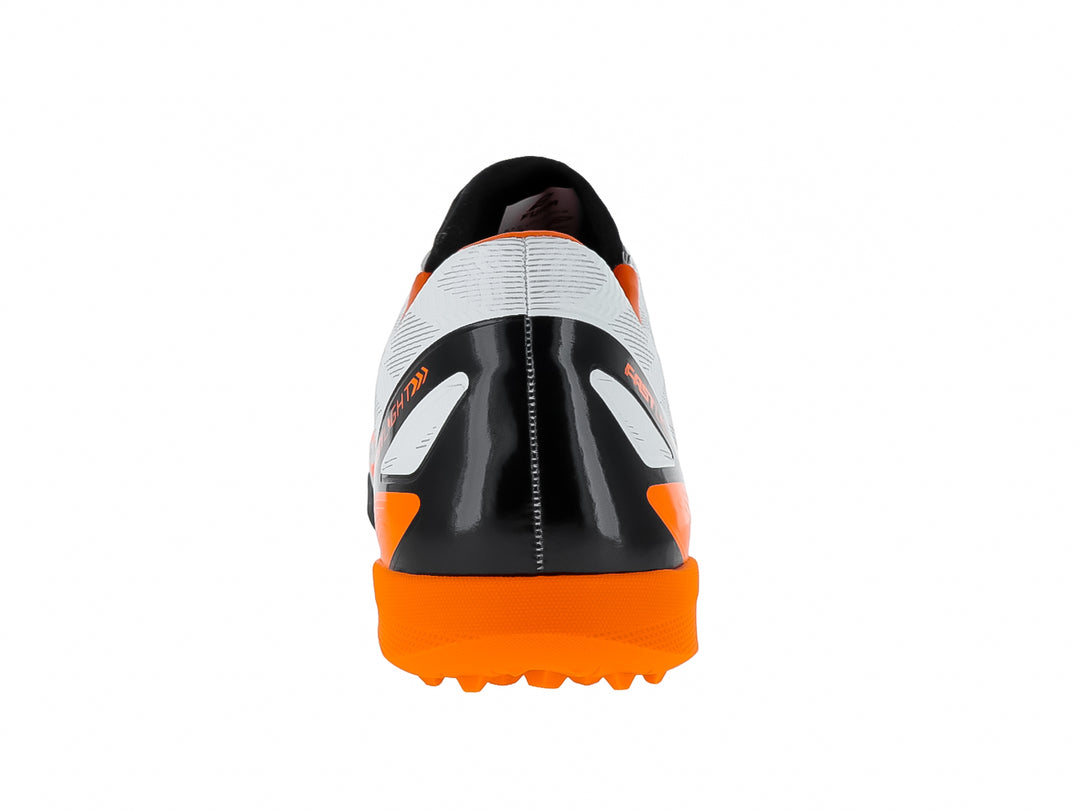 Zapato de fútbol Furia blanco con detalles naranjas y suela negra para pasto sintético.