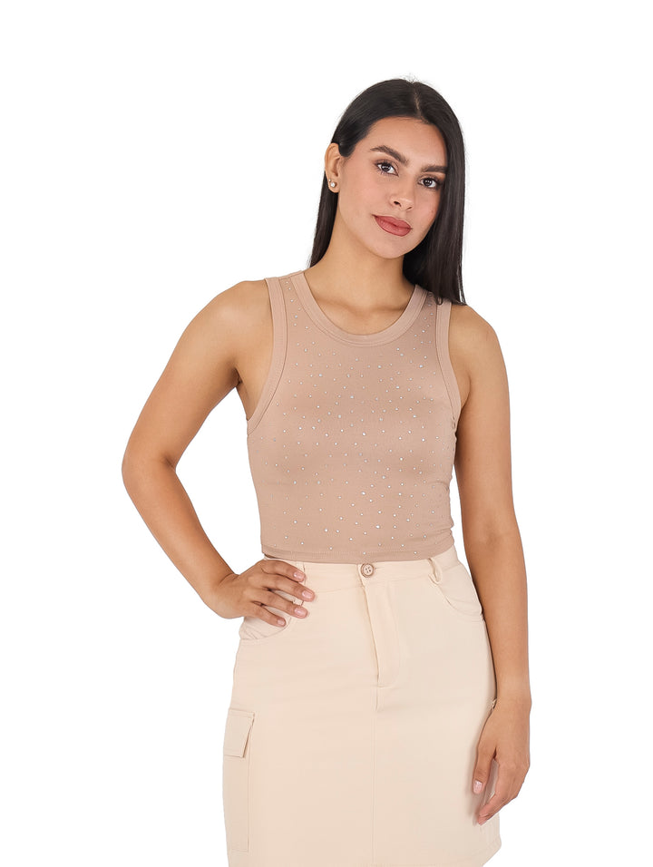 Mujer vistiendo un top beige ajustado sin mangas con detalles de pequeñas piedras brillantes.