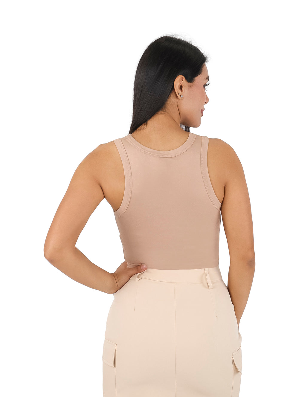 Mujer vistiendo un top beige ajustado sin mangas con detalles de pequeñas piedras brillantes.