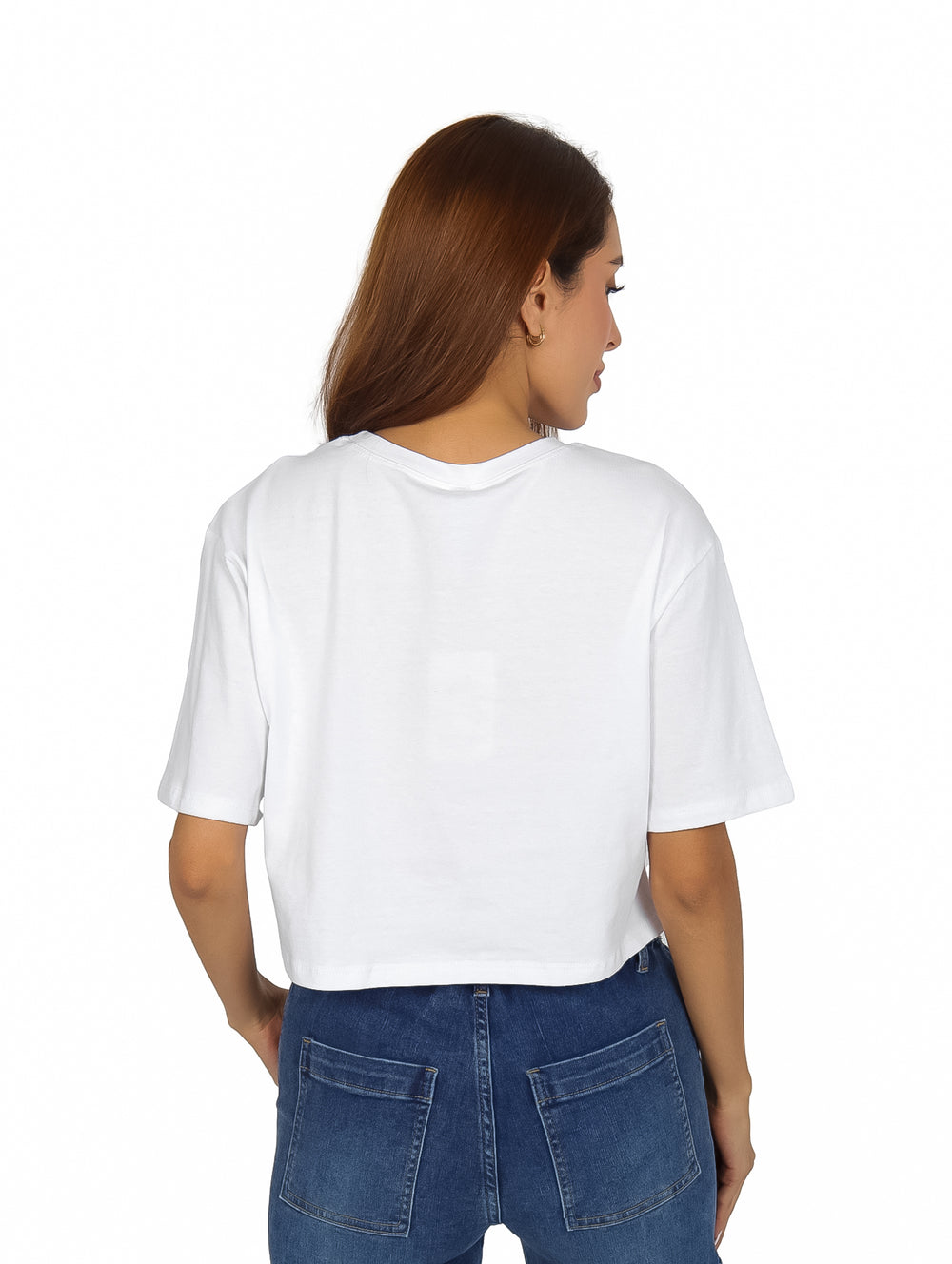 Mujer vistiendo playera corta blanca con estampado de rostro en blanco y negro y pantalones cargo azules.