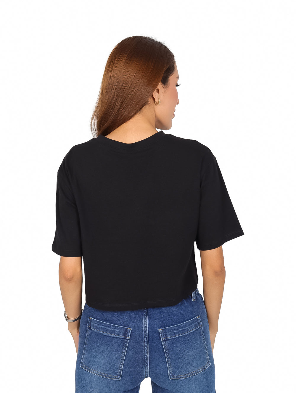 Mujer vistiendo playera negra de manga corta con estampado colorido de botas vaqueras y jeans azules.