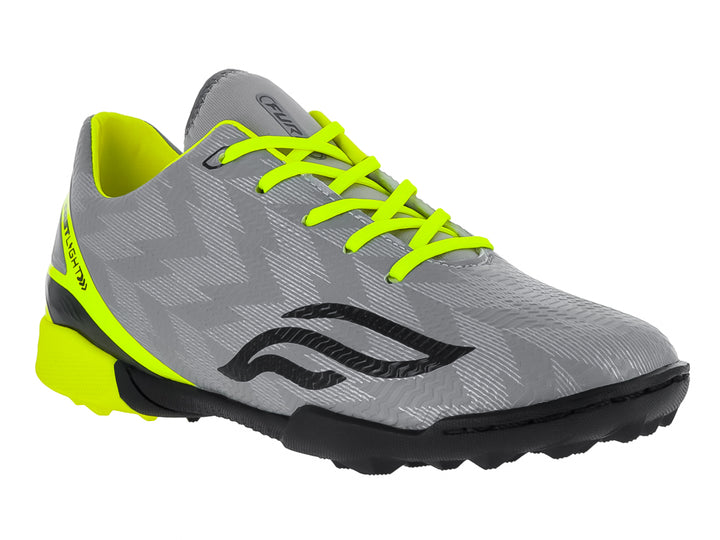 Zapato de fútbol Furia para niños en color gris con detalles en amarillo neón y suela negra para césped sintético.