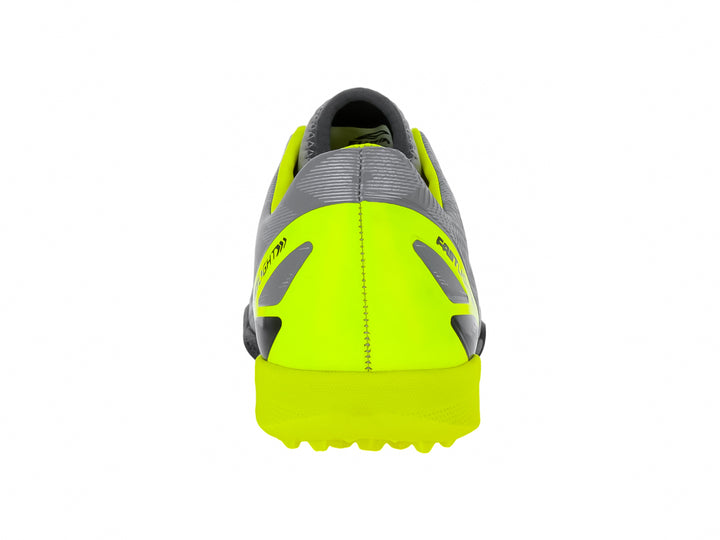 Zapato de fútbol Furia para niños en color gris con detalles en amarillo neón y suela negra para césped sintético.