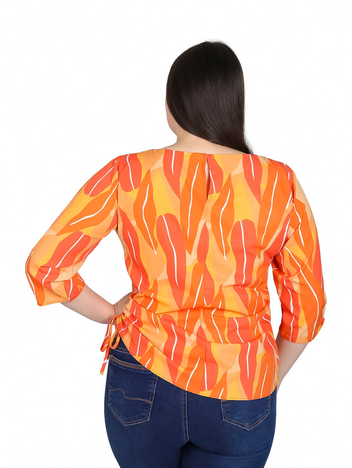 Mujer vistiendo blusa naranja con estampado abstracto y mangas 3/4.