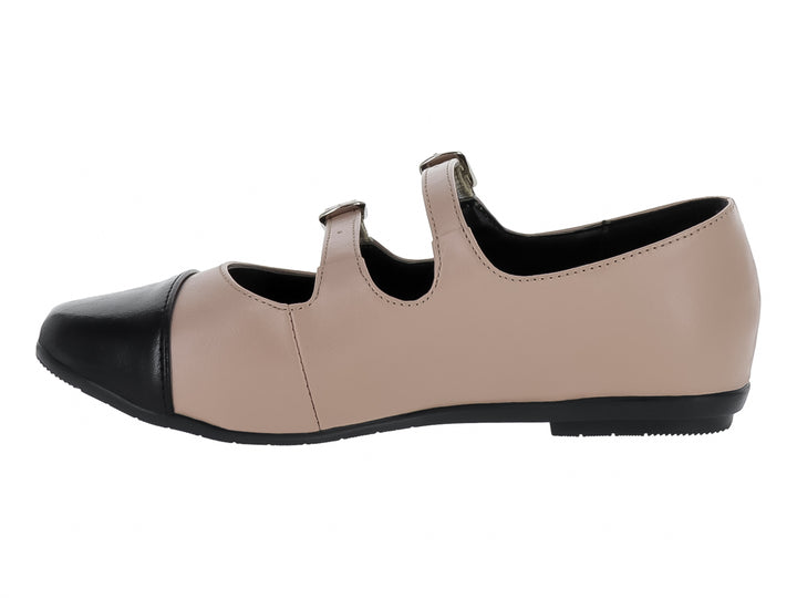 Zapato plano color maquillaje con punta negra y dos correas con hebillas plateadas.