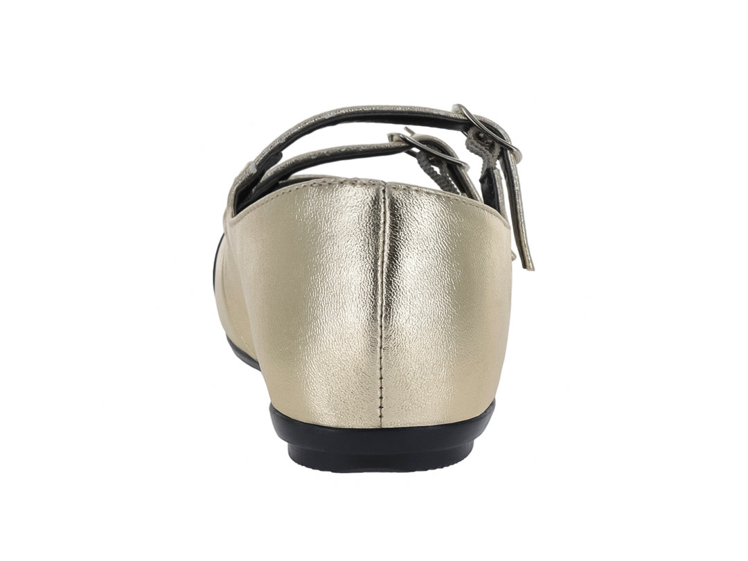 Zapato plano color oro con punta negra y dos correas con hebilla.