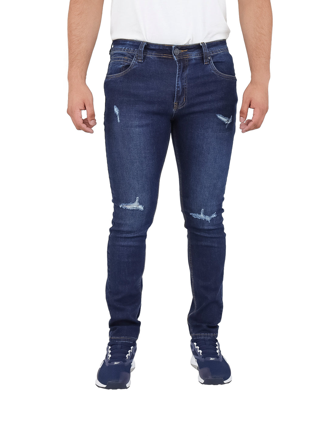 Hombre vistiendo pantalones jeans azul marino con detalles desgastados.