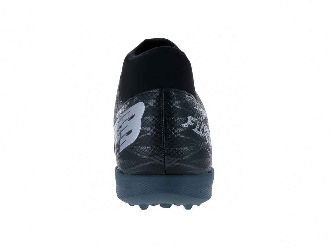 Calzado de fútbol Furia en color negro con detalles grises y suela para césped sintético.