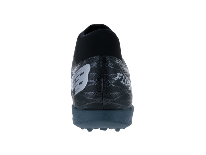 Calzado de fútbol Furia en color negro con detalles grises y suela para césped sintético.