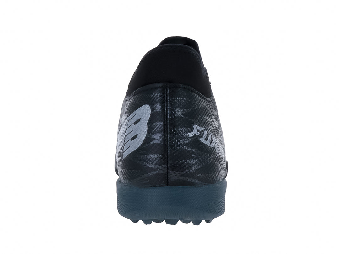 Zapato de fútbol Furia para niño en color negro con detalles en gris oxford y suela para césped sintético.