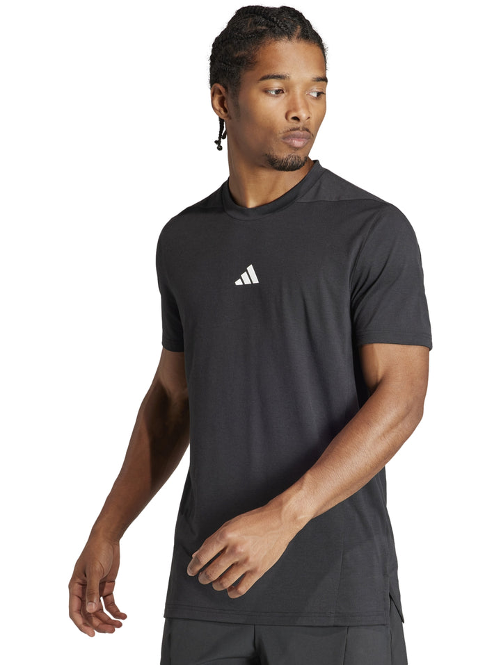 Hombre vistiendo una camiseta deportiva Adidas de color negro con manga corta y cuello redondo.