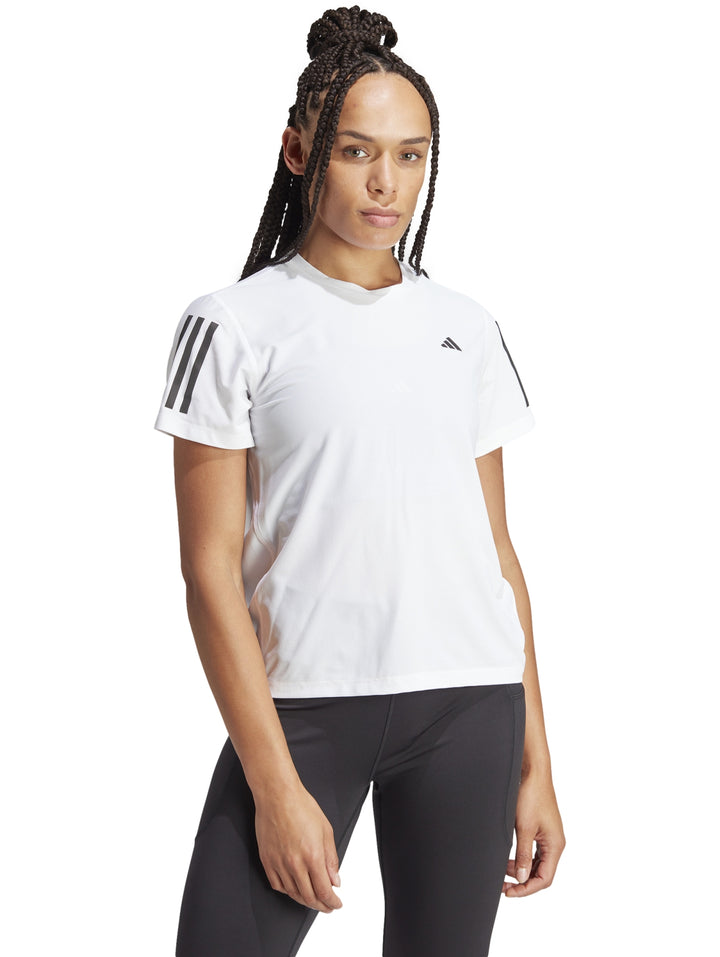 Camiseta deportiva blanca de manga corta con detalles negros en los hombros, marca Adidas.