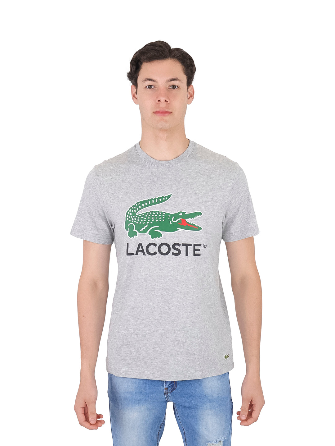 Hombre vistiendo una camiseta gris de manga corta con el logotipo de Lacoste en el pecho.