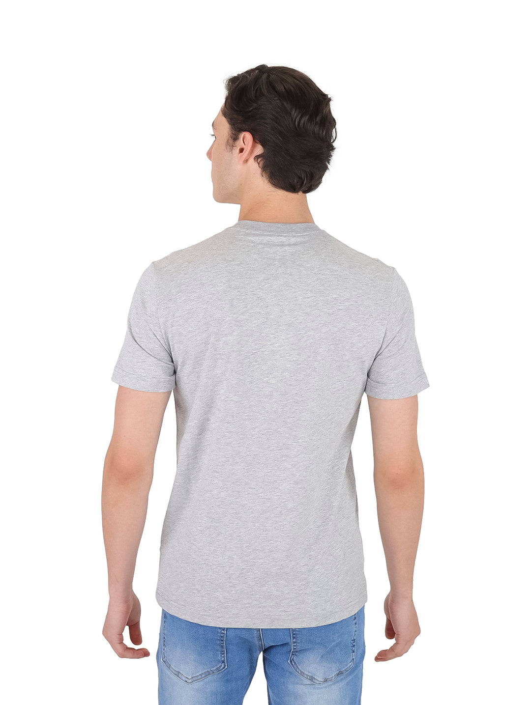Hombre vistiendo una camiseta gris de manga corta con el logotipo de Lacoste en el pecho.