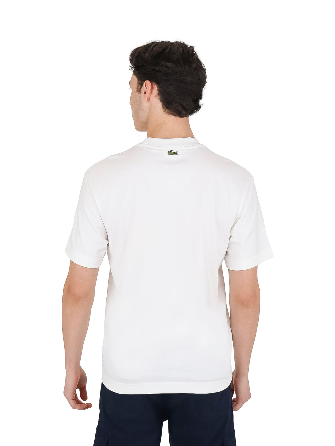 Hombre vistiendo camiseta blanca de manga corta y cuello redondo con logo pequeño en el pecho.