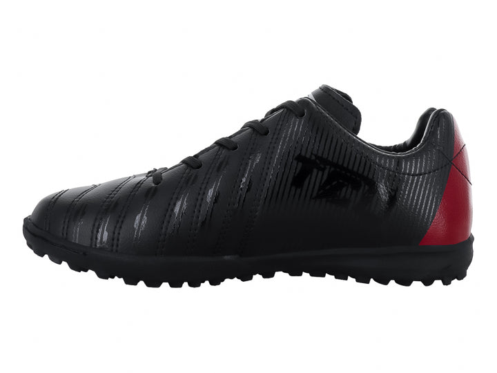 Zapato de fútbol Leon Trucco color negro con detalle rojo en el talón y suela para césped sintético.