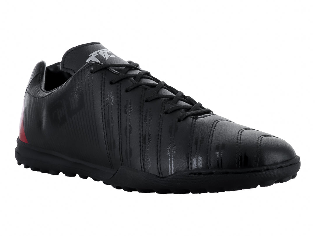 Zapato de fútbol Leon Trucco color negro con detalle rojo en el talón y suela para césped sintético.