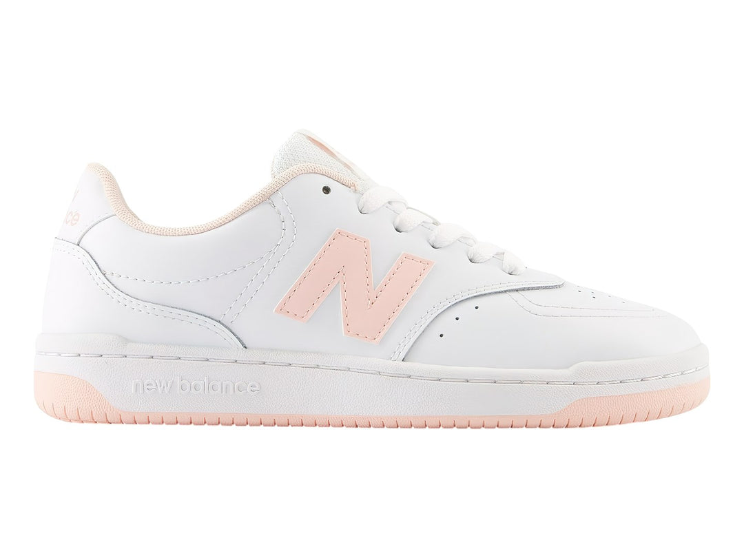 Tenis New Balance blancos con detalles en rosa y suela rosa claro para niña.