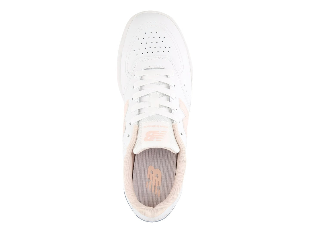 Tenis New Balance blancos con detalles en rosa y suela rosa claro para niña.