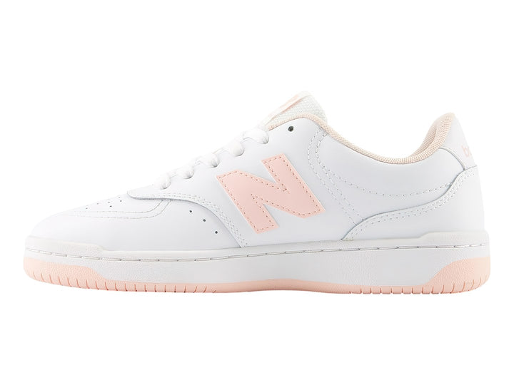 Tenis New Balance blancos con detalles en rosa y suela rosa claro para niña.