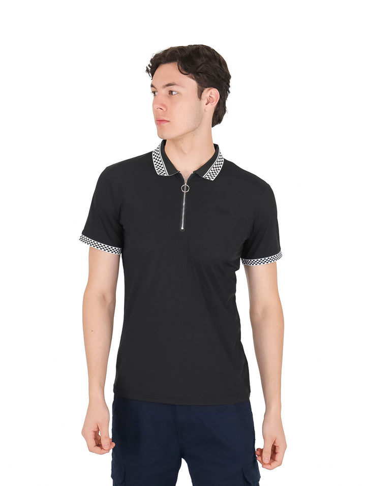 Hombre vistiendo playera polo negra de manga corta con cuello y puños a cuadros y cierre frontal.