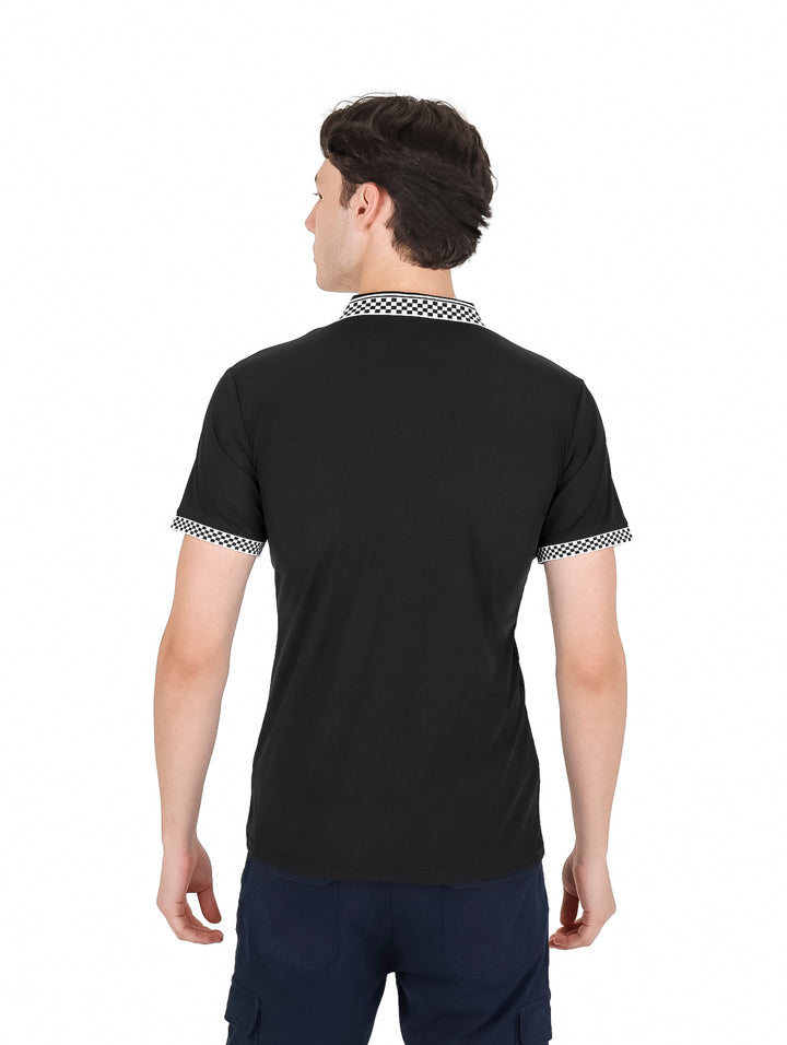 Hombre vistiendo playera polo negra de manga corta con cuello y puños a cuadros y cierre frontal.