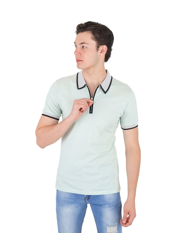 Hombre vistiendo playera polo color verde pistache con ribete oscuro en cuello y mangas.
