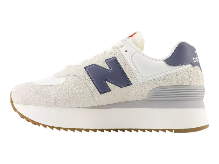 Tenis New Balance WL574Z color moonbeam con detalles púrpura y suela de plataforma blanca.