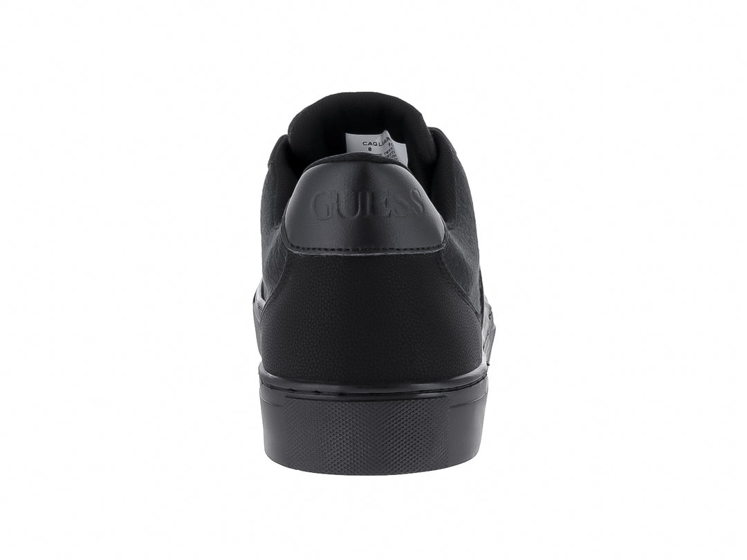 Tenis negros GUESS de corte bajo con suela plana y detalles texturizados.