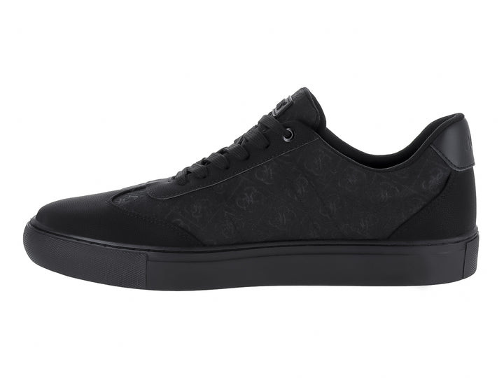 Tenis negros GUESS de corte bajo con suela plana y detalles texturizados.