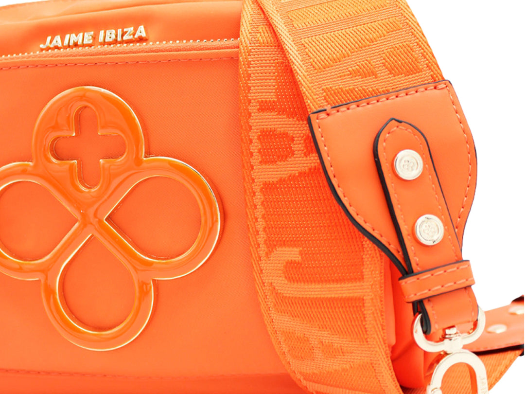 Bolso color naranja de Jaime Ibiza con correa ajustable y detalle decorativo central.
