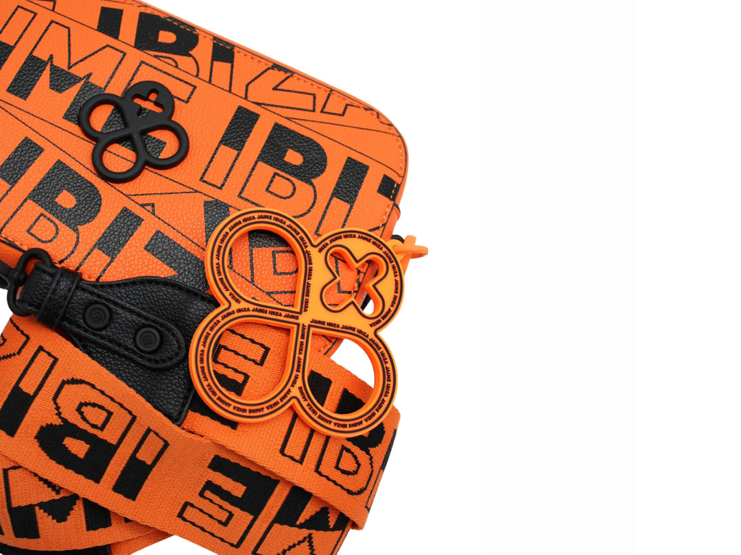 Bolso rectangular naranja con estampado de letras negras y correa ajustable.