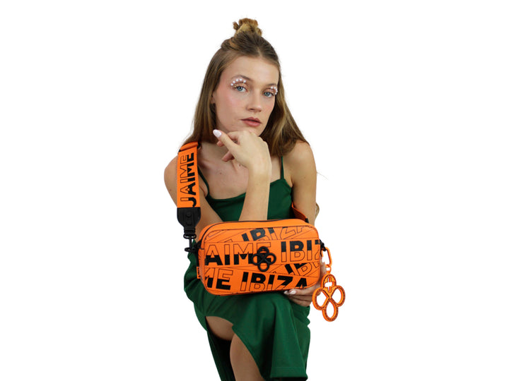 Bolso rectangular naranja con estampado de letras negras y correa ajustable.