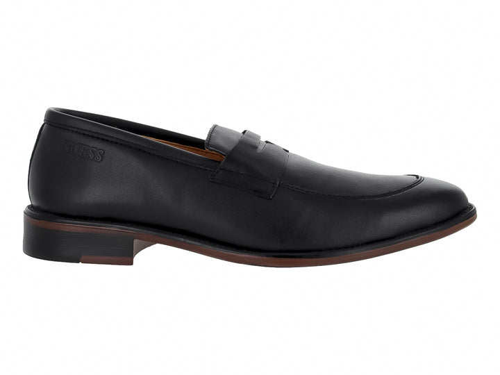 Zapato mocasín de cuero negro marca GUESS con diseño elegante y suela oscura.
