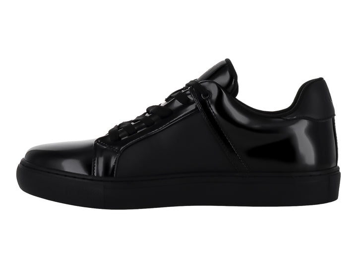 Tenis Guess color negro monocromo con acabado brillante y suela plana para hombre.