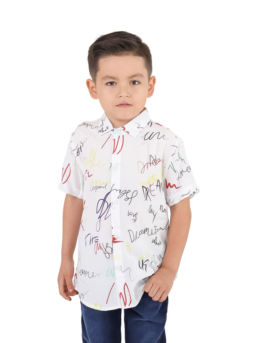 Niño vistiendo una camisa blanca de manga corta con estampados abstractos coloridos.