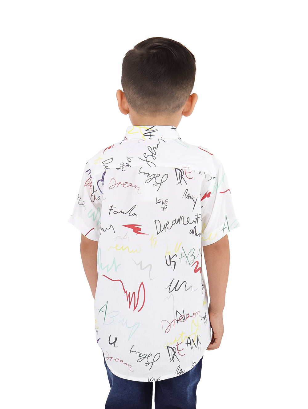 Niño vistiendo una camisa blanca de manga corta con estampados abstractos coloridos.