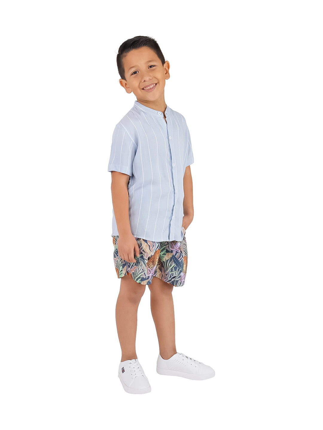 Niño vistiendo camisa de manga corta color azul acero con rayas blancas verticales.
