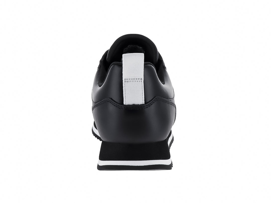 Tenis negros de cuero Calvin Klein con suela blanca dentada y cordones negros.