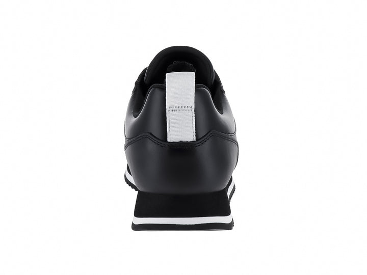 Tenis negros de cuero Calvin Klein con suela blanca dentada y cordones negros.